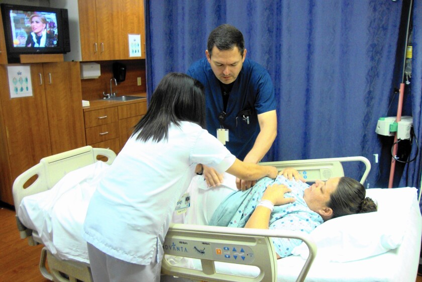 Dr. Rolando Guerrero checks on Crystal, a Mexican woman who had an emergency caesarean section the previous day at Starr County Memorial Hospital in Rio Grande City, Texas.