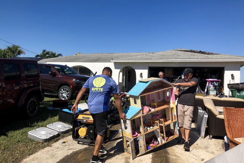 Cape Coral, Florida - October 01: Family and friends of Ignacio Soto moves recovered possessions on to the driveway of his home on Saturday, Oct. 1, 2022 in Cape Coral, Florida days after Hurricane Ian passed through the area. The hurricane brought high winds, storm surge and rain to the area causing severe damage. (Jenny Jarvie / Los Angeles Times)Cape Coral, Florida - October 01: on Saturday, Oct. 1, 2022 in Cape Coral, Florida days after Hurricane Ian passed through the area. The hurricane brought high winds, storm surge and rain to the area causing severe damage. (Jenny Jarvie / Los Angeles Times)