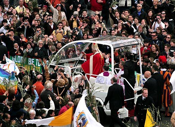 In St. Peter's Square, Pope Benedict XVI greets the crowd from a partially enclosed popemobile after attending Palm Sunday Mass last month.