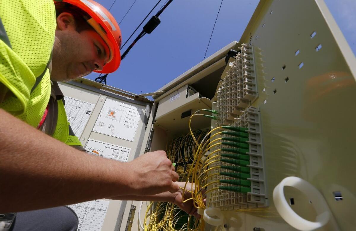 Frontier Communications technician Airik Morales checks a utility box that serves as a hub for the company's network in Long Beach.