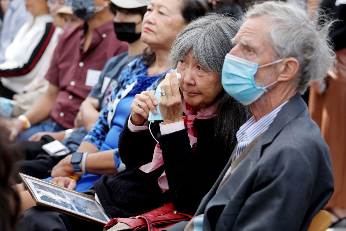 A woman sitting in the audience wipes tears from her eyes