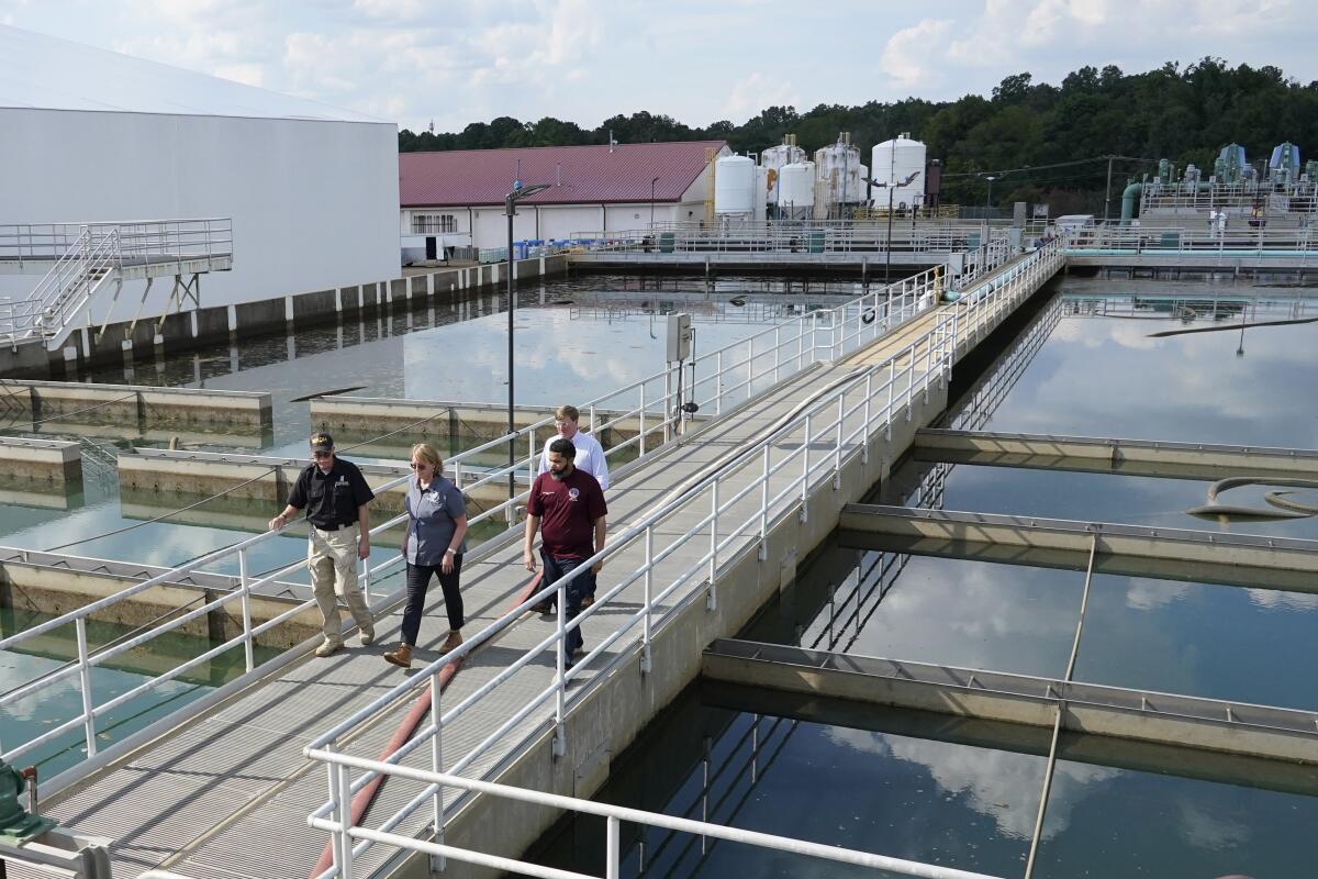 Jim Craig, with the Mississippi State Department of Health, left, leads Jackson Mayor Chokwe Antar Lumumba, right, Deanne Criswell, administrator of the Federal Emergency Management Agency (FEMA), center, and Mississippi Gov. Tate Reeves, rear, as they walk past sedimentation basins at the City of Jackson's O.B. Curtis Water Treatment Facility in Ridgeland, Miss., Friday, Sept. 2, 2022. Jackson's water system partially failed following flooding and heavy rainfall that exacerbated longstanding problems in one of two water-treatment plants. (AP Photo/Rogelio V. Solis, Pool)
