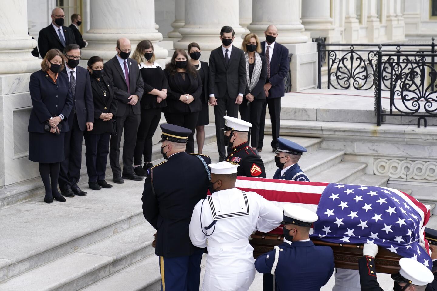 Family members watch as the casket of Justice Ruth Bader Ginsburg is carried by a military honor guard into the Capitol