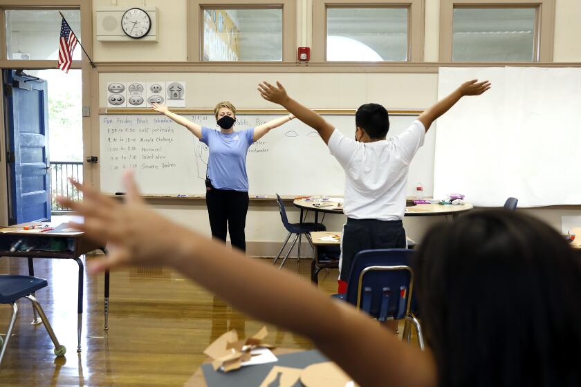 PASADENA, CALIFORNIA: Nelli Tergrigoryan leads students in a stretching exercise during a LEARNs summer program at Washington Elementary School in Pasadena on Friday, July 9, 2021. In the wake of pandemic-related learning loss, districts across California had high hopes for Summer programs that might help catch kids up-and there's unprecedented state funding to do so. (Christina House / Los Angeles Times)