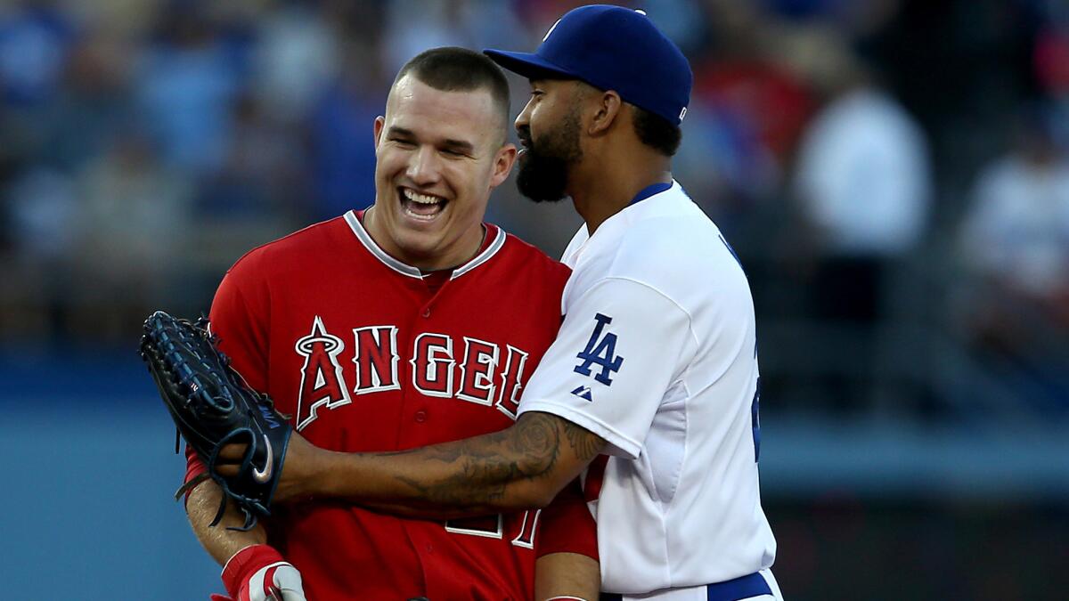 Angels baserunner Mike Trout, left, shares a laugh with Dodgers right fielder Matt Kemp after being called out on a double play during the first inning of a game on Aug. 5.