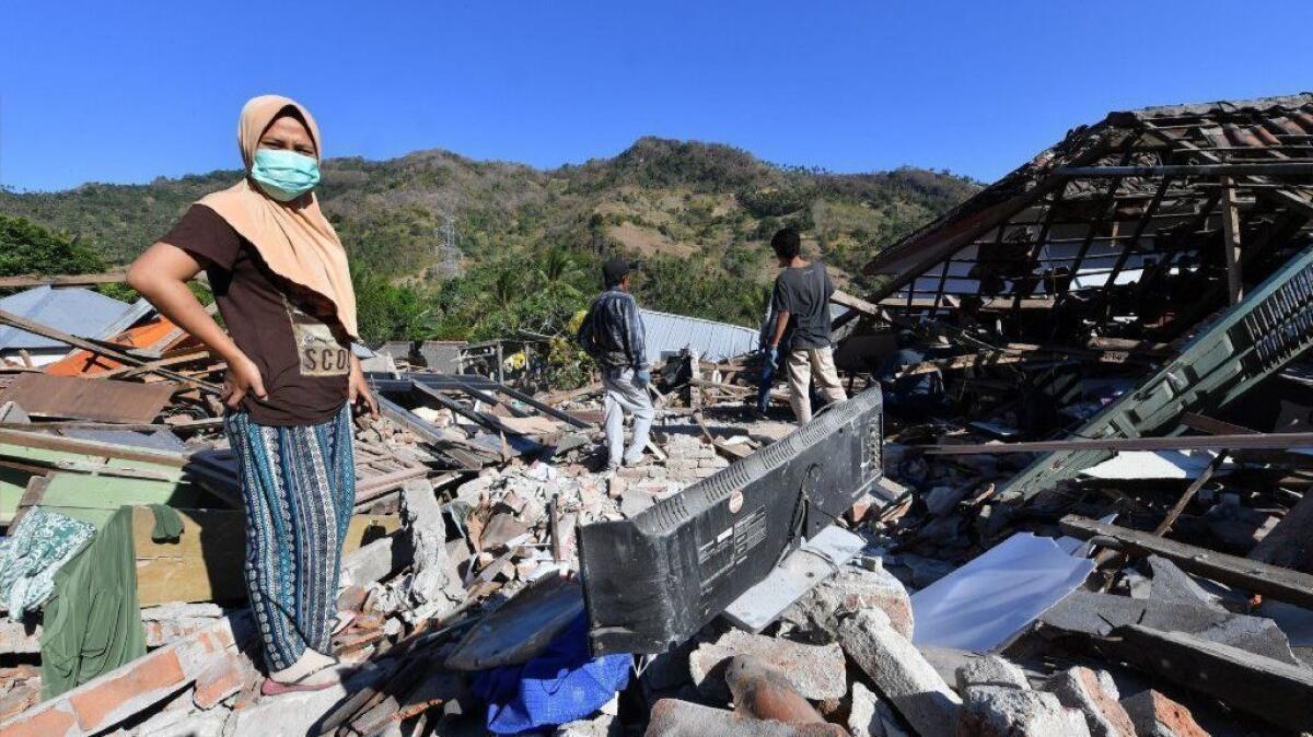 People search for their belongings in damaged houses in Menggala, north Lombok, on Aug. 8, 2018.