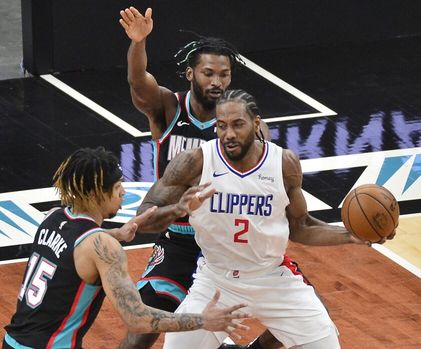 Clippers forward Kawhi Leonard handles the ball between Memphis Grizzlies' Brandon Clarke and Justise Winslow on Feb. 25.