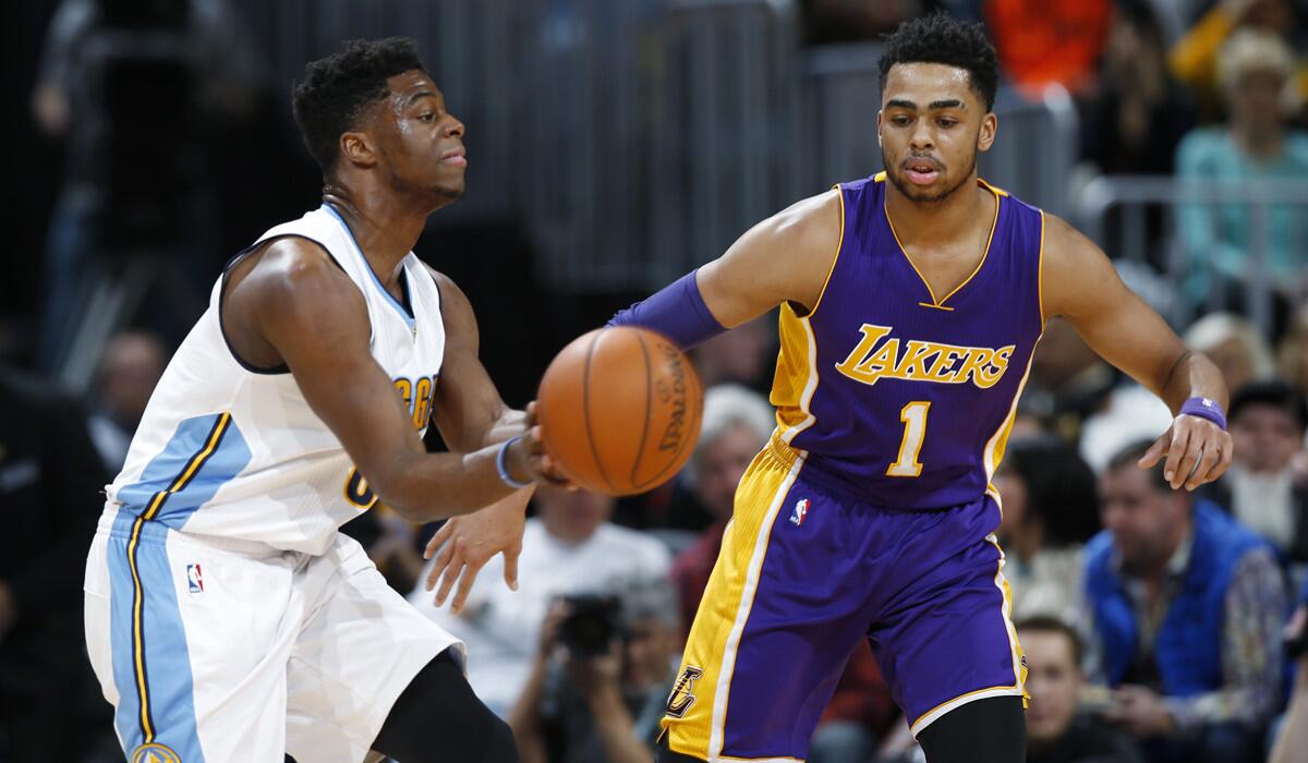 Denver Nuggets guard Emmanuel Mudiay, left, passes the ball as Lakers guard D'Angelo Russell defends in the first half Wednesday.