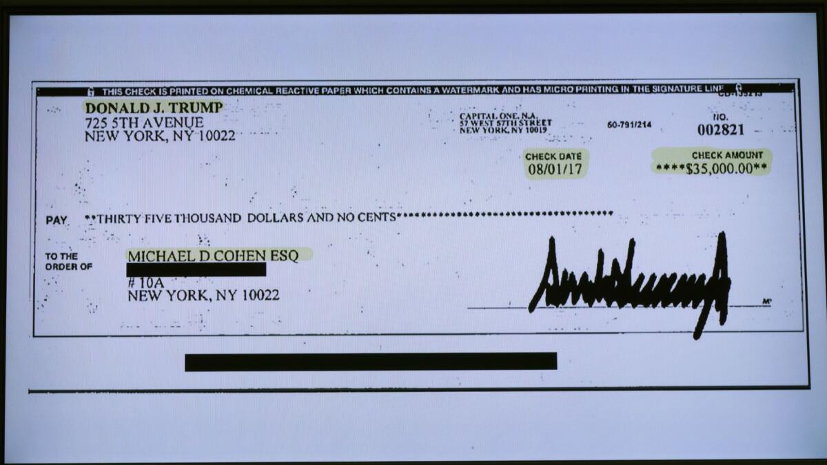 A copy of a check paid to Michael Cohen by President Trump is displayed as Cohen, former attorney and fixer for Trump, testifies before the House Oversight Committee on Capitol Hill.