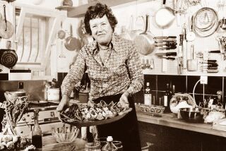 In this 1978 photo, Julia Child shows off a salade nicoise she prepared in the kitchen of her vacation home in southern France.