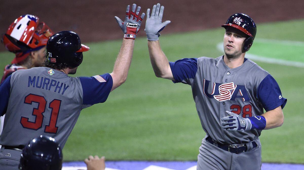 Buster Posey (28) is congratulated by Daniel Murphy after hitting a solo home run for the U.S. during the fifth inning of a World Baseball Classic game against Puerto Rico in San Diego on Friday.