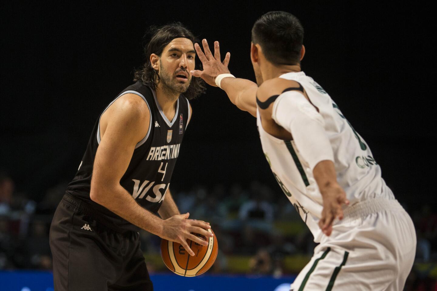 Gustavo Ayón, de México, marca a Luis Scola, de Argentina, durante un encuentro del Preolímpico de las Américas, disputado el miércoles 9 de septiembre de 2015 en la capital mexicana (AP Foto/Christian Palma) ** Usable by HOY and ELSENT Only **