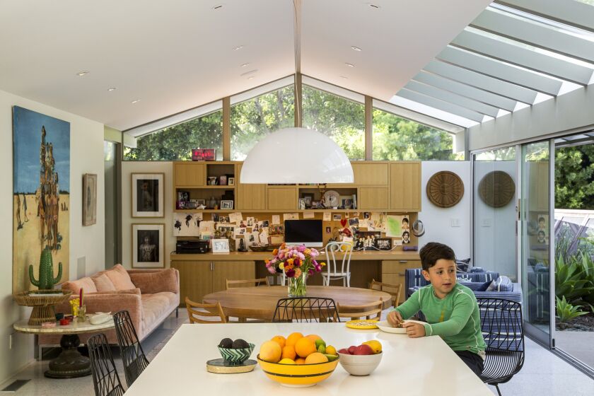 Architect John Bertram transformed a 1963 home by Pasadena-based architects Smith & Williams for a family of four. Here, 10-year-old Harry has lunch in the new kitchen, which was moved from the front of the house to the back.