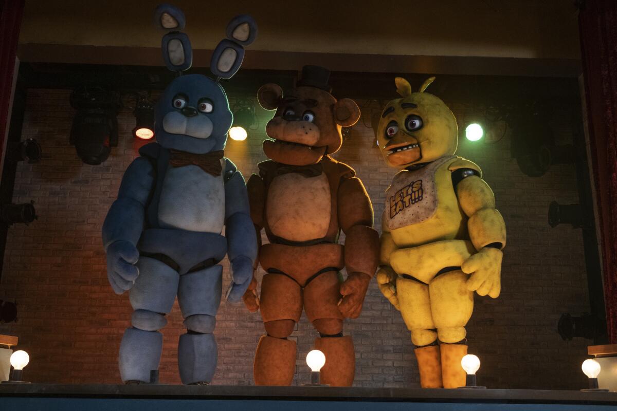 Three animatronics — a blue bunny with a red bowtie, a brown bear with a black hat and a yellow duck.