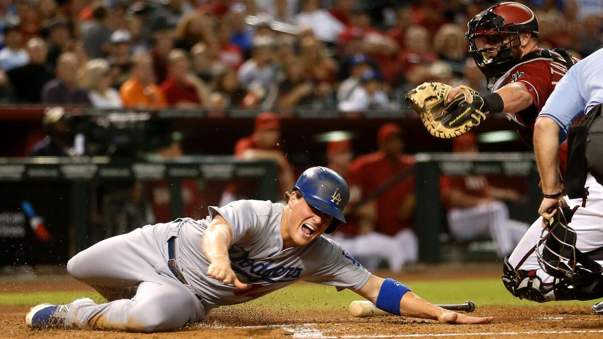 Dodgers outfielder Enrique Hernandez avoids the tag attempt of Diamondbacks catcher Jarrod Saltalamacchia to score a run in the third inning in Phoenix on July 1.