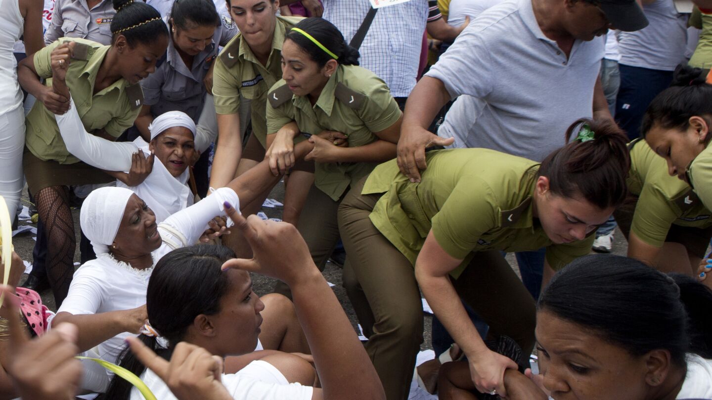 Policewomen drag away members of Ladies in White, a women's dissident group that calls for the release of political prisoners, during the group's weekly protest in Havana on Sunday.