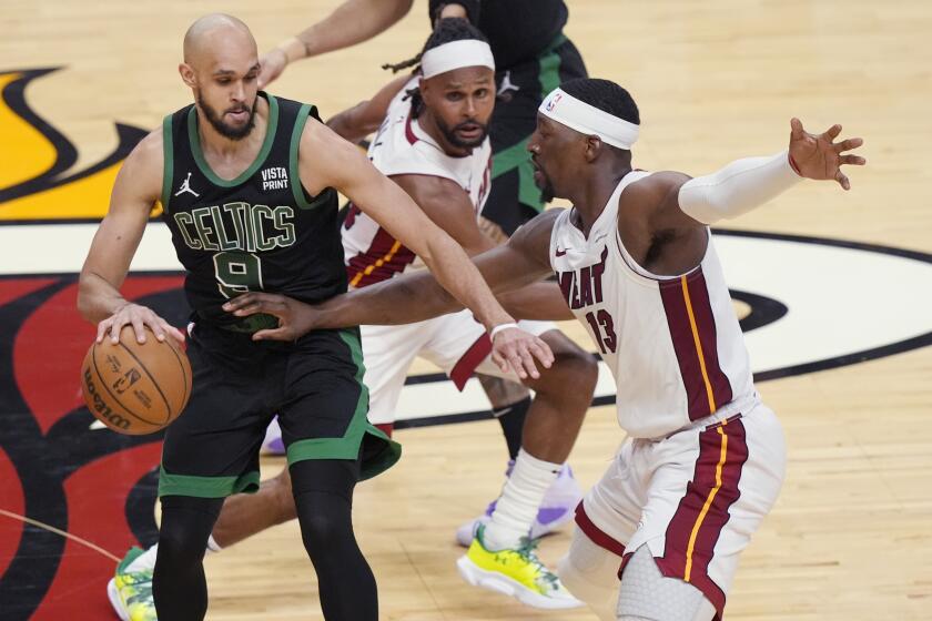 Boston Celtics guard Derrick White (9) dribbles as Miami Heat center Bam Adebayo (13) defends during the second half of Game 4 of an NBA basketball first-round playoff series, Monday, April 29, 2024, in Miami. (AP Photo/Marta Lavandier)