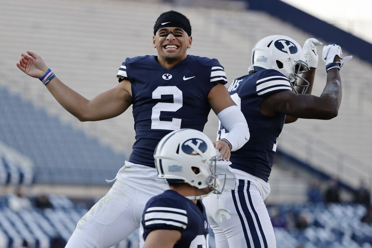 BYU wide receiver Neil Pau'u (2) congratulates running back Miles Davis, right, after his fourth quarter touchdown against North Alabama during an NCAA college football game Saturday, Nov. 21, 2020, in Provo, Utah. (AP Photo/Jeff Swinger, Pool)