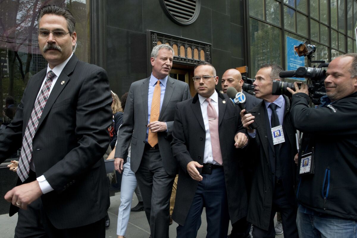 New York City Mayor Bill de Blasio is surrounded by security.