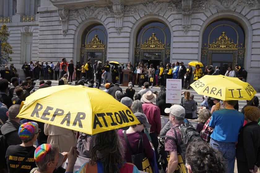 People listen during a rally in support of reparations for African Americans outside City Hall in San Francisco, Tuesday, Sept. 19, 2023. (AP Photo/Eric Risberg)