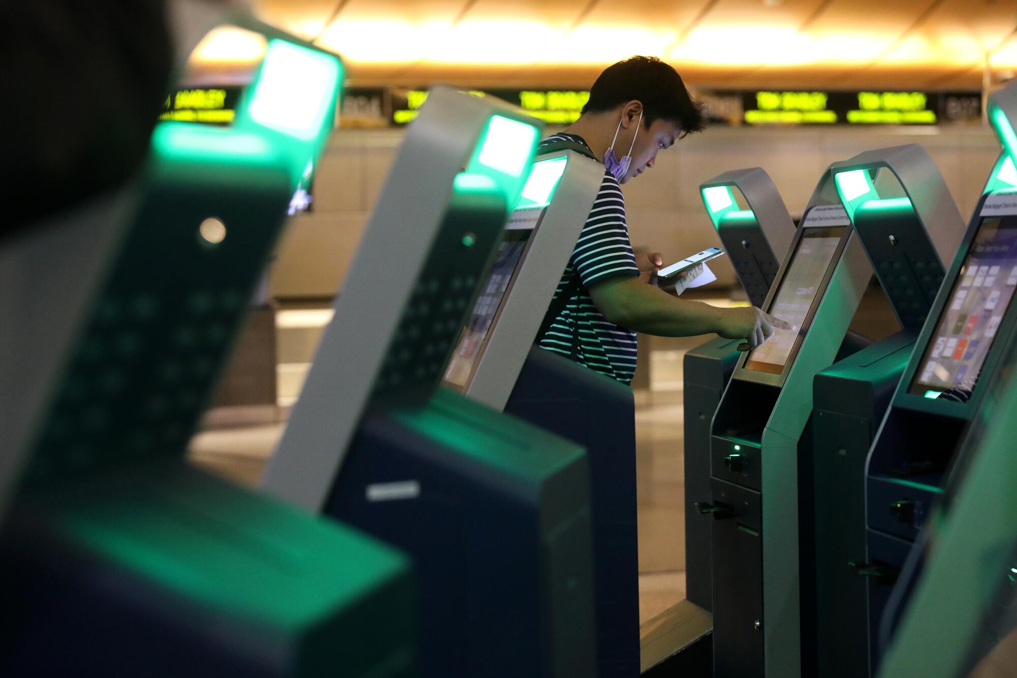 A passenger checks in for a flight at the empty Tom Bradley International Terminal.