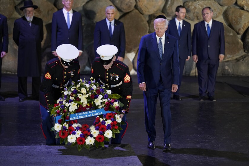 President Biden watches as a wreath is laid.
