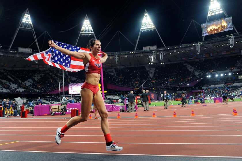 Jennifer Suhr carries the American flag after winning the gold medal in pole vault.