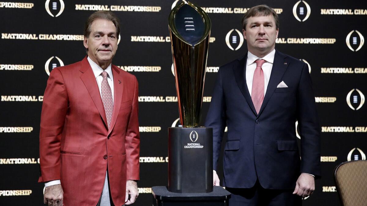 Alabama coach Nick Saban, left, and Georgia coach Kirby Smart pose with the NCAA football championship trophy at a news conference in Atlanta on Jan. 7. No. 1 Alabama plays No. 4 Georgia in the Southeastern Conference title game Saturday.