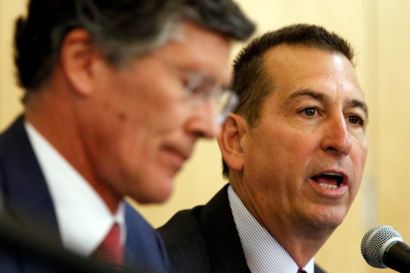 LOS ANGELES, CA - FEBRUARY 26, 2015: CIT CEO John A. Thain, left, and OneWest CEO Joseph M. Otting, right, speak Thursday February 26, 2015 at the Federal Reserve branch in Los Angeles hearing on the $3.4 billion takeover of OneWest Bank in Pasadena by NY business lender CIT Group.(Al Seib / Los Angeles Times)
