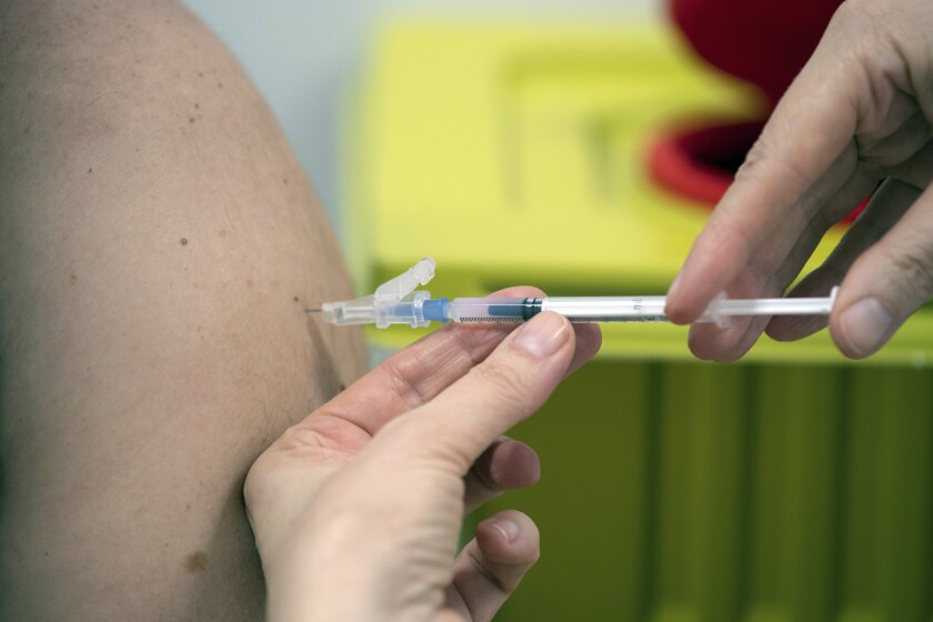 A member of staff at the university hospital injects the Moderna vaccine against COVID-19 into a patient in Duesseldorf, Monday, Jan. 18, 2021. (Federico Gambarini/dpa via AP)