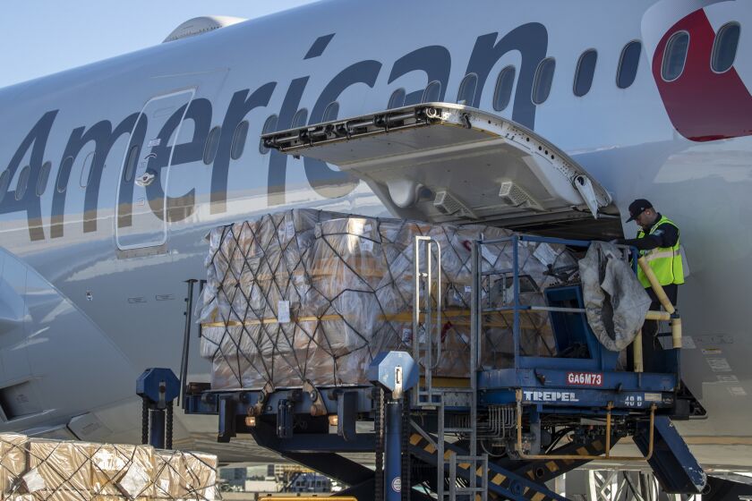 LOS ANGELES, CALIF. -- MONDAY, NOVEMBER 26, 2018: Cargo is unloaded from an inbound American Airlines flight from Beijing at LAX in Los Angeles, Calif., on Nov. 26, 2018. (Brian van der Brug / Los Angeles Times)