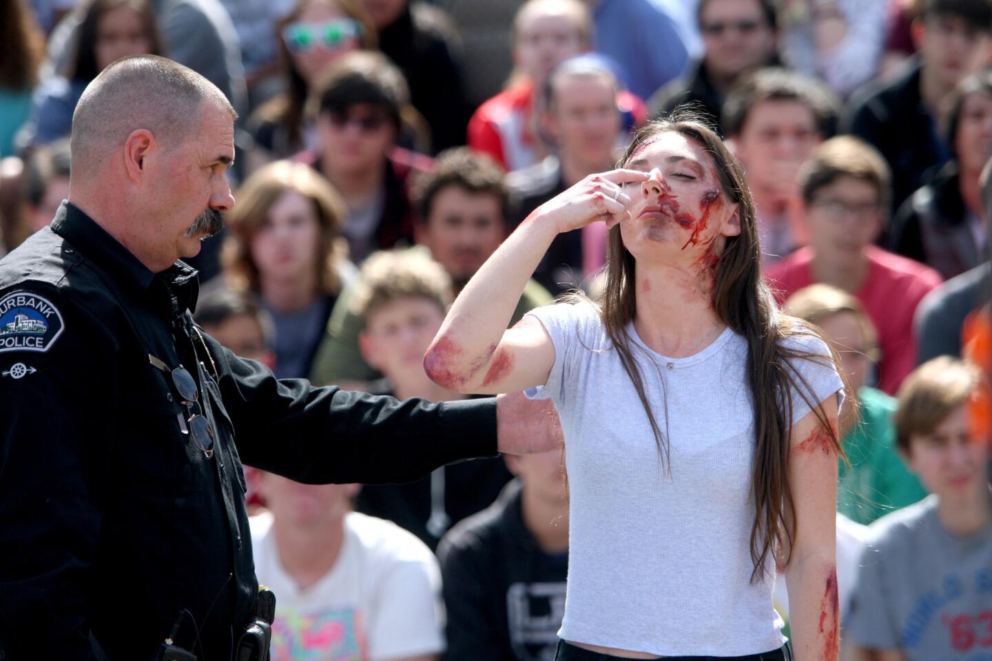 During the "Every 15 Minutes" simulation, Burbank police officer Todd Burns gives sobriety test to actor and student Emily Cox, in front of Burroughs High School, in Burbank on Thursday, April 21, 2016. "Every 15 Minutes" is a program with real cars, police, fire and coroner dept. personnel and actor students who act out a scene of a multiple-vehicle accident with fatalities. The program warns students on the dangers of drunk driving.
