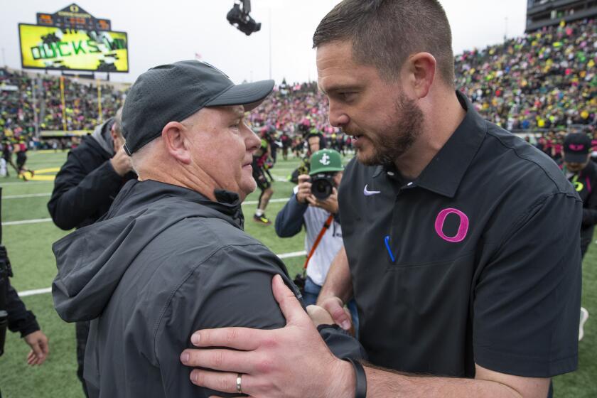 UCLA coach Chip Kelly, left, and Oregon coach Dan Lanning meet at midfield.
