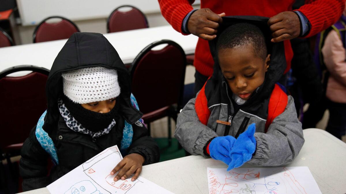 Pre-kindergarten students get bundled up at the end of the day as they wait to be picked up Tuesday at Lakewood Elementary School in Baltimore. Recent cold weather exposed the poor state of school buildings in many East Coast cities.