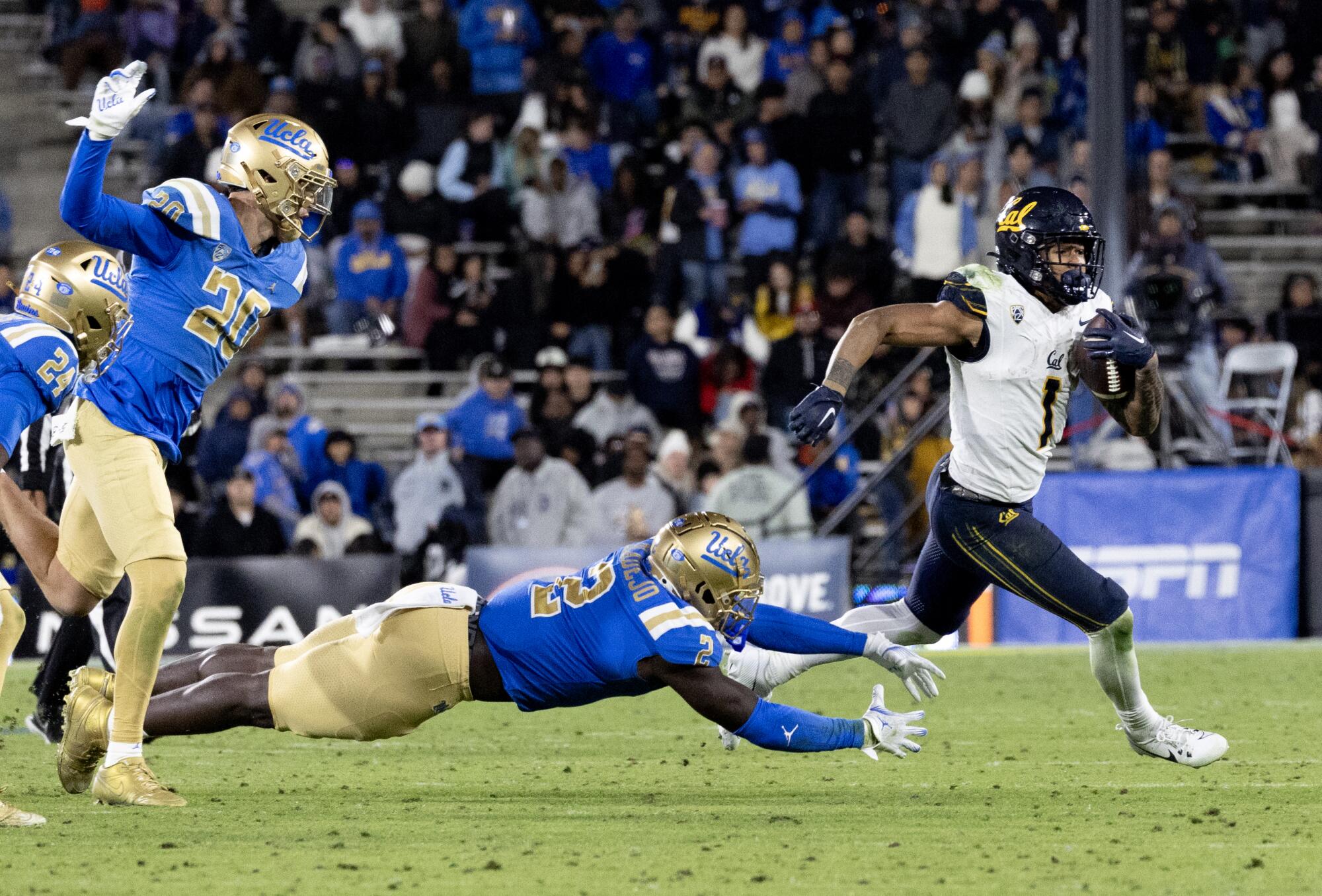 Cal running back Jaydn Ott evades a tackle attempt by UCLA linebacker Oluwafemi Oladejo at the Rose Bowl Saturday.