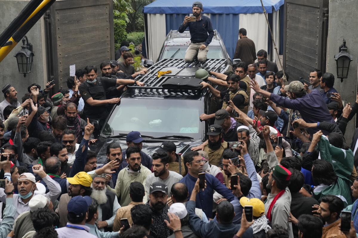 Supporters surround a vehicle carrying former Pakistani Prime Minister Imran Khan from his residence in Lahore.
