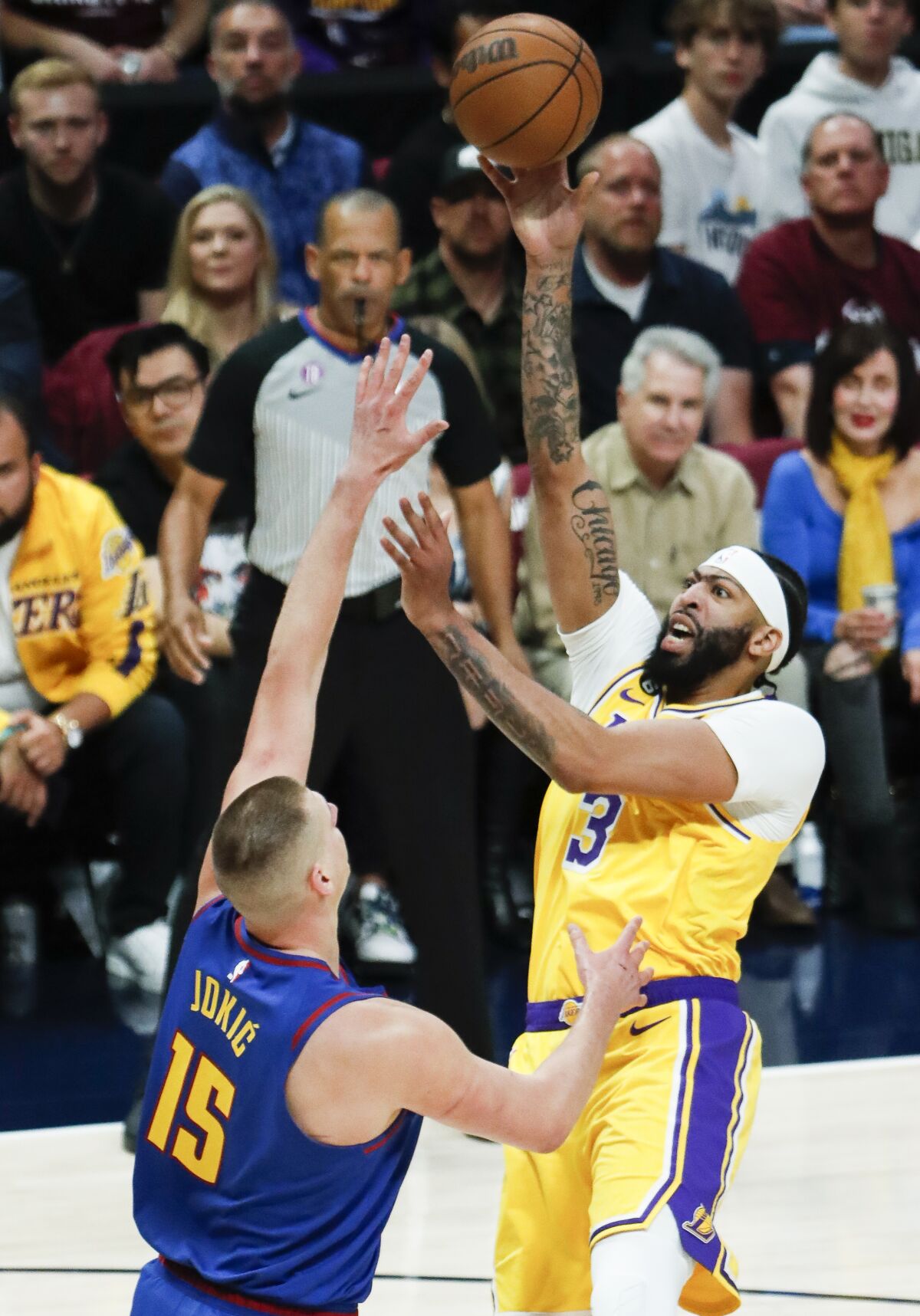 Lakers forward Anthony Davis, right, shoots over Nuggets center Nikola Jokic in the lane.