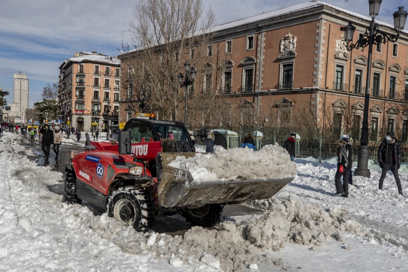 A plough clears snow in downtown Madrid, Spain, Sunday, Jan. 10, 2021. A large part of central Spain including the capital of Madrid are slowly clearing snow after the country's worst snowstorm in recent memory. (AP Photo/Manu Fernandez)