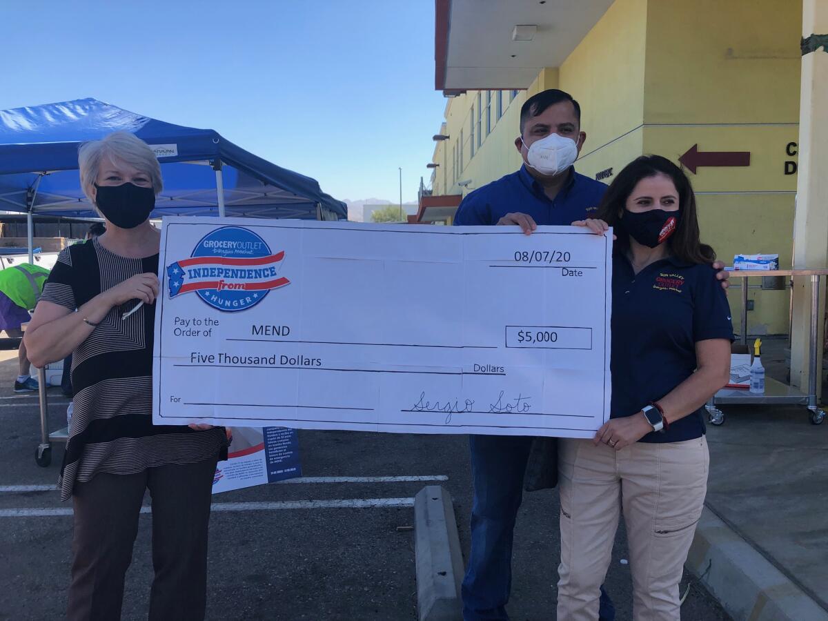 Los propietarios de Grocery Outlet, en Sun Valley, entregaron cheque a Janet Marinaccio, presidenta de MEND (izquierda).