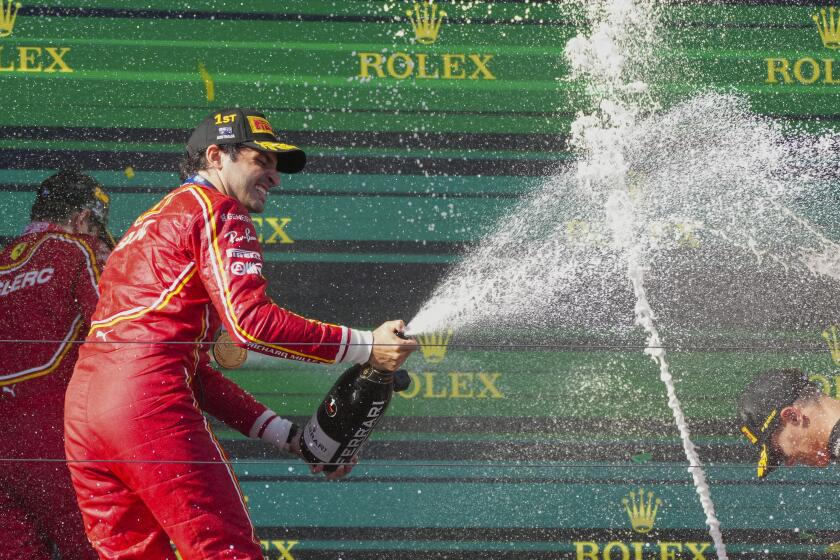 El piloto español de Ferrari Carlos Sainz rocía champán mientras celebra su victoria en el Gran Premio de Australia en Albert Park, Melbourne, Australia, el domingo 24 de marzo de 2024. (AP Foto/Scott Barbour)
