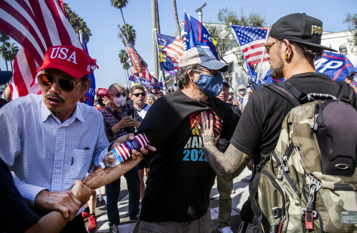 Joe Biden supporter Richard Williams, 70, of Irvine is grabbed and shoved by Donald Trump supporters.