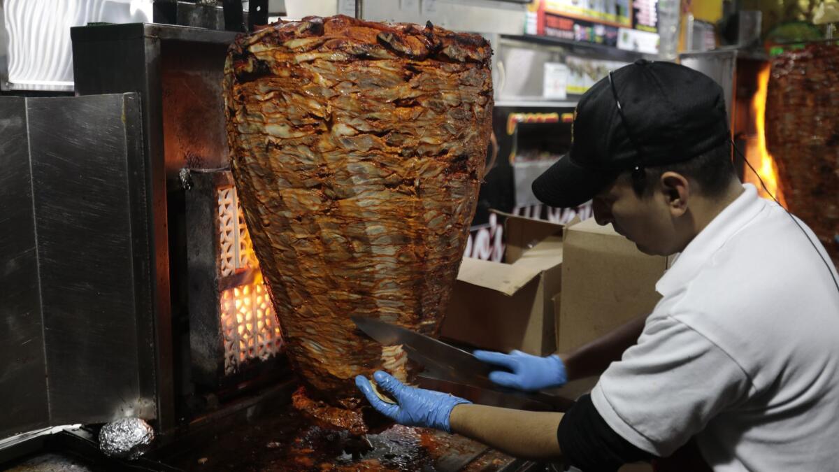 Morsels of meat are shaved from a spit for al pastor tacos at Leo's Taco Truck at South La Brea Avenue and Venice Boulevard.