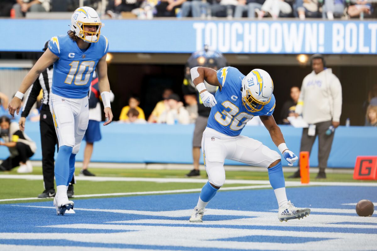 Chargers running back Austin Ekeler celebrates his touchdown and Justin Herbert (10) joins him.