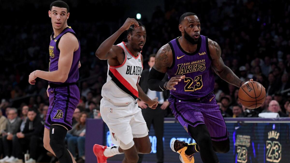 Lakers forward LeBron James drives past Trail Blazers forward Al-Farouq Aminu after a screen by teammate Lonzo Ball during their game Nov. 14.