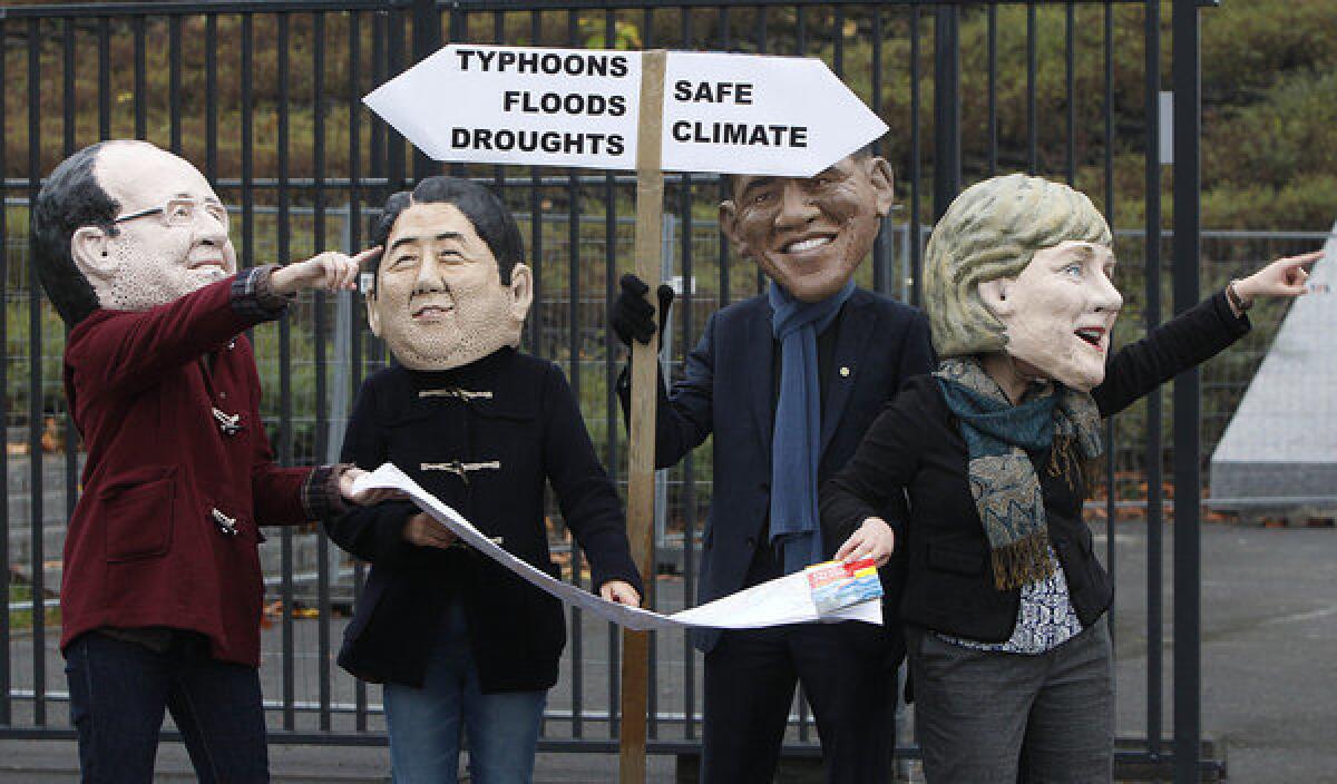 Environmental activists lampoon what they see as a lack of leadership in the fight against global warming, with protesters Friday donning the likenesses of French President Francois Hollande, left, Japanese Prime Minister Shinzo Abe, President Obama and German Chancellor Angela Merkel in a demonstration outside the United Nations climate conference in Warsaw.