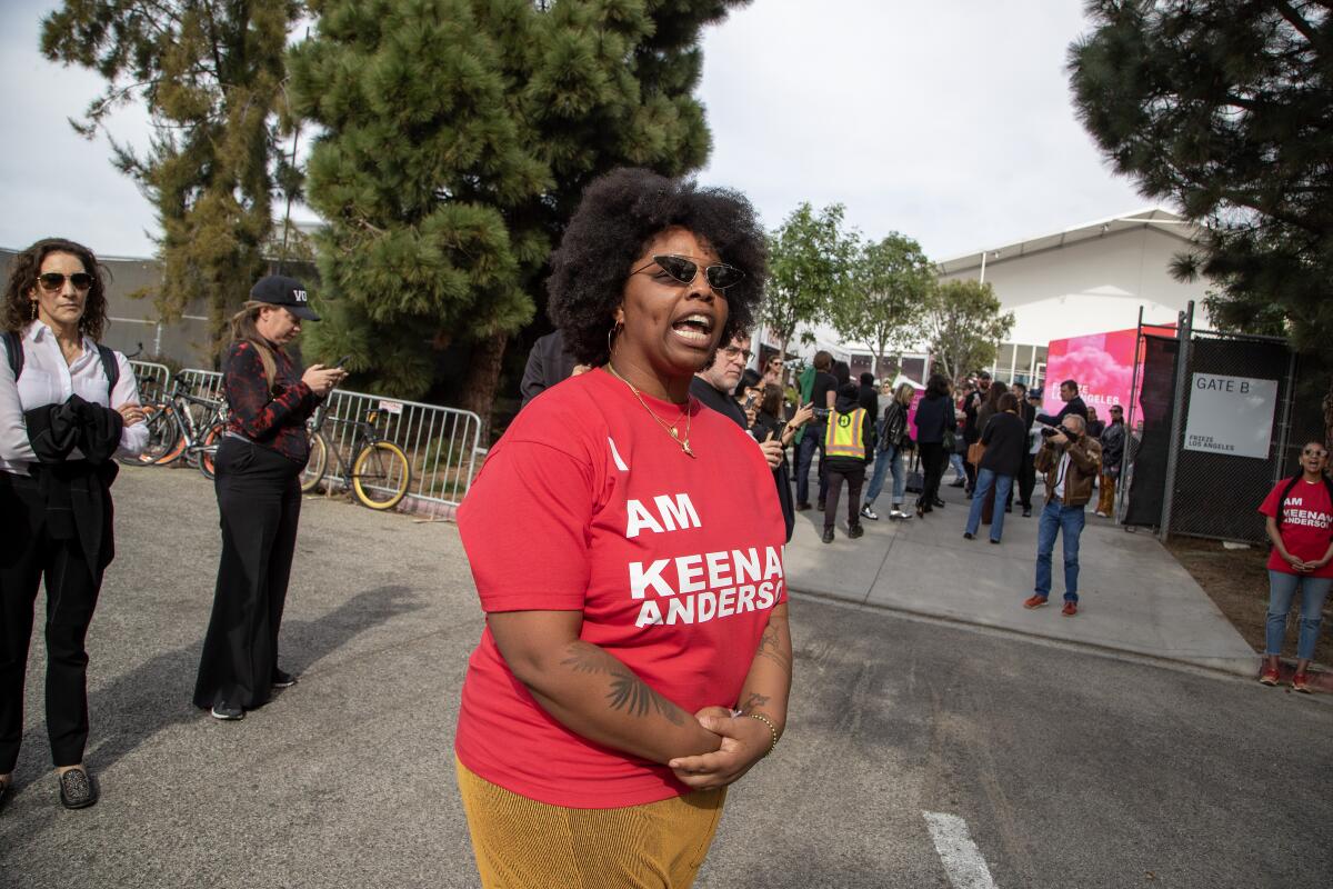 A woman in an "I am Keenan Anderson" T-shirt speaks