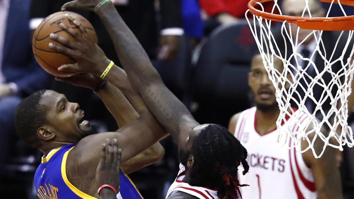 Warriors forward Kevin Durant has his shot challenged by Rockets forward Montrezl Harrell during the first half Friday night.
