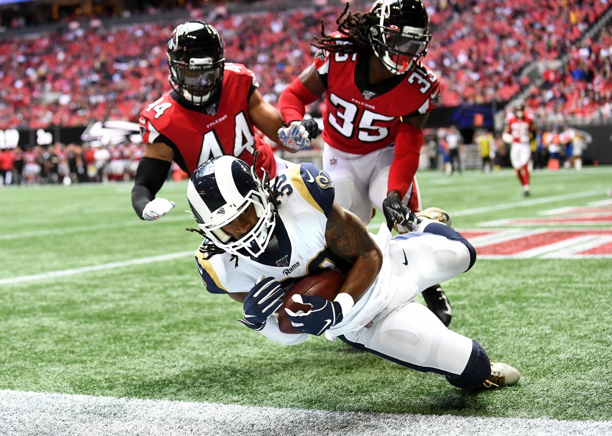 Rams running back Todd Gurley catches a touchdown pass in front of Falcons linebacker  Vic Beasley Jr., left, and safety Jamal Carter.