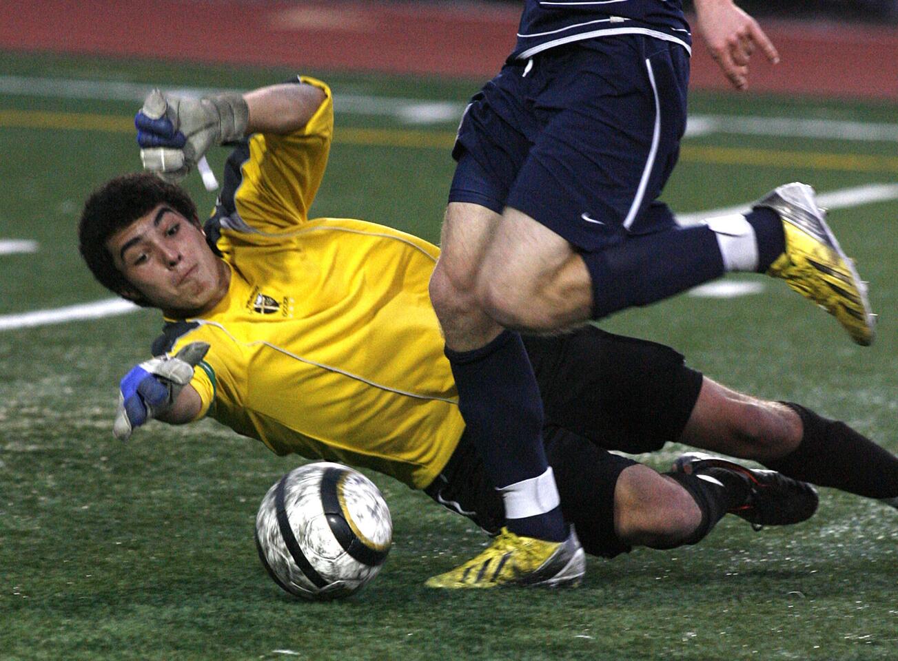 St. Francis' Luca Coppola drops and reaches for the ball as Notre Dame's Kyle Ause successfully gets the ball around him to score in the first half in a Mission League soccer match at St. Francis High School in La Canada Flintridge on Monday, February 4, 2013. Notre Dame won the game 4-0.