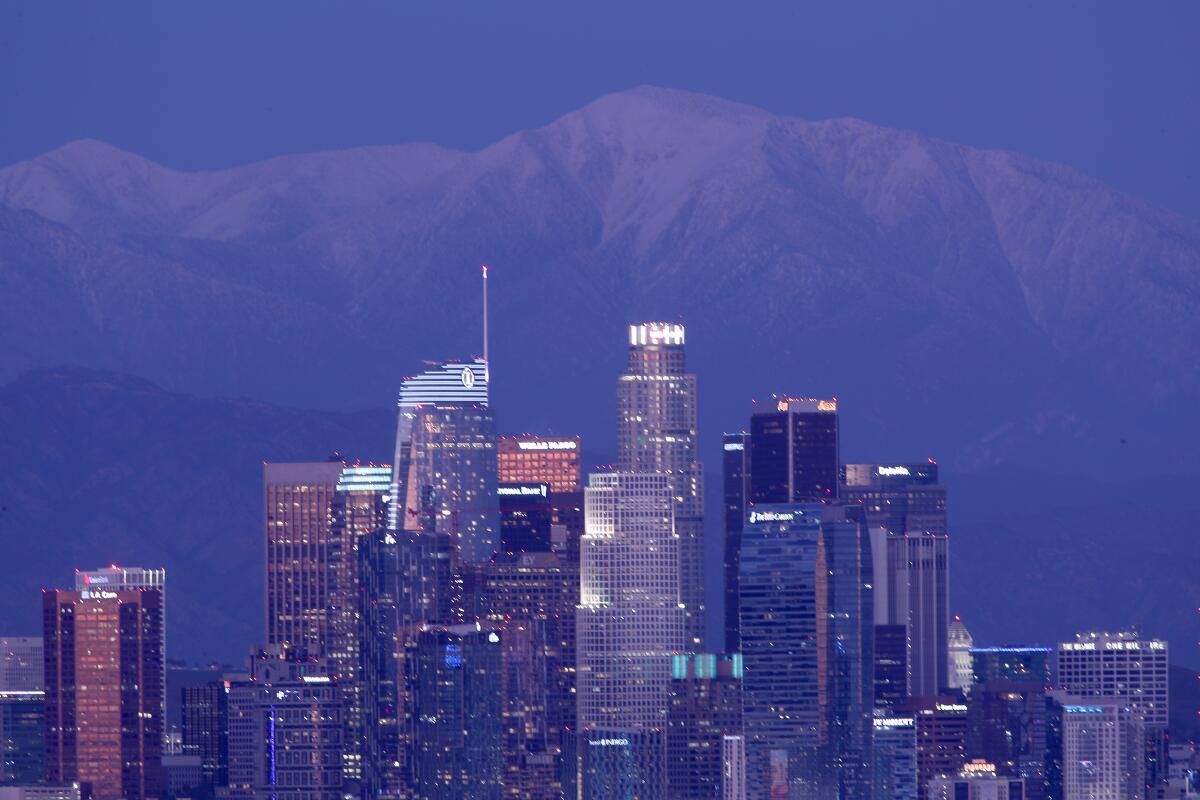 Snow covers Mt. Baldy behind the Los Angeles skyline.
